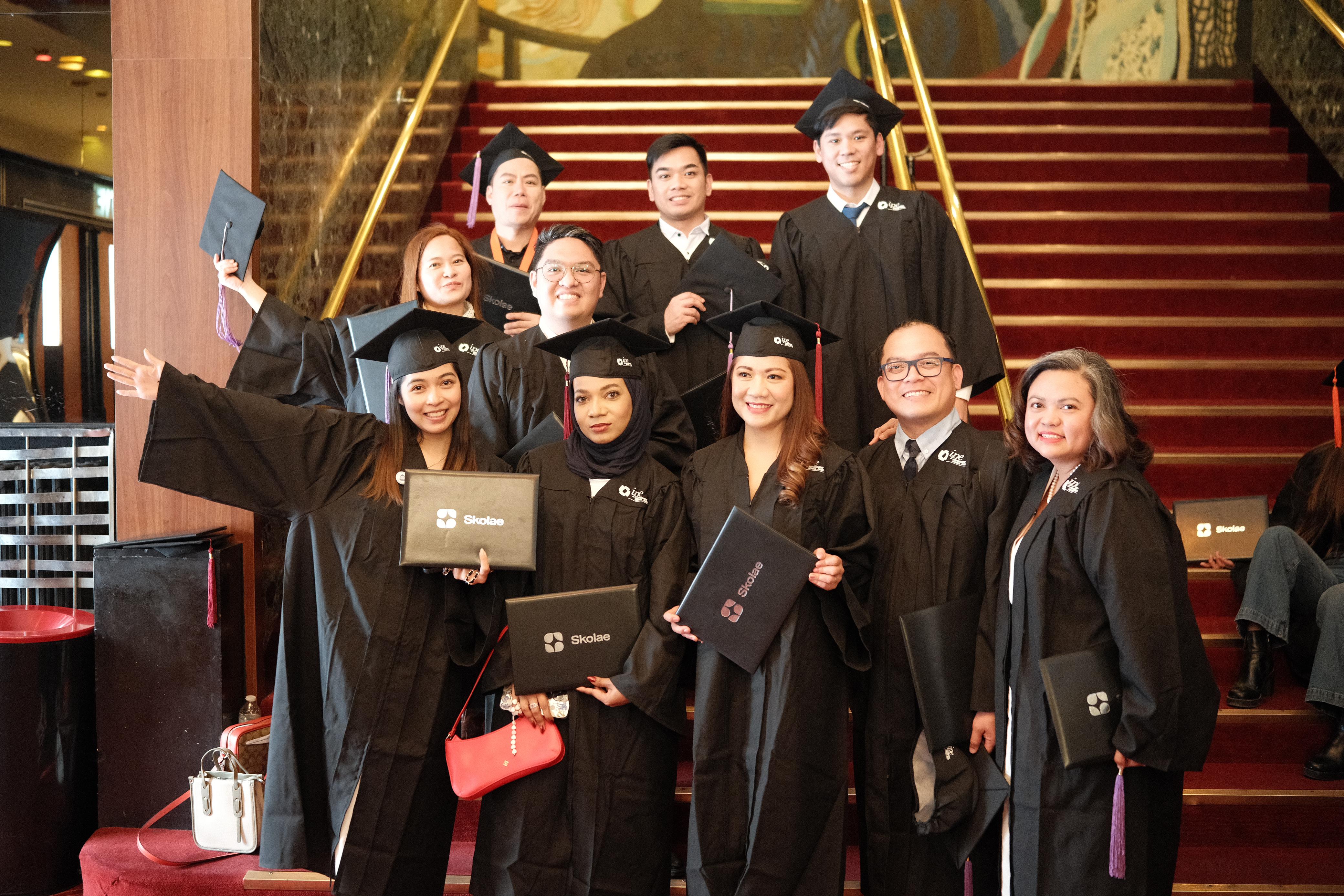 PPA Business School graduates celebrating together on the grand staircase in Paris after their graduation ceremony
